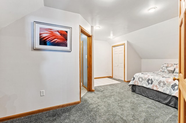 bedroom featuring light carpet, lofted ceiling, and a closet