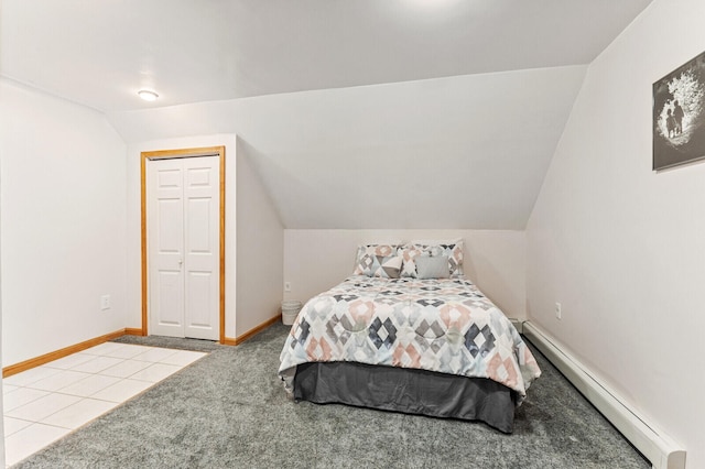 carpeted bedroom with lofted ceiling, a baseboard heating unit, and a closet