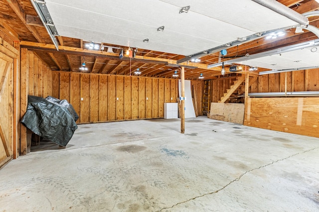 garage with wood walls and a garage door opener