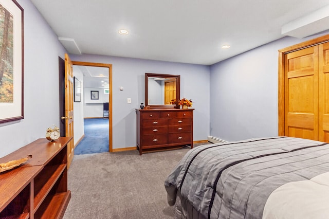 bedroom with a baseboard heating unit and light carpet