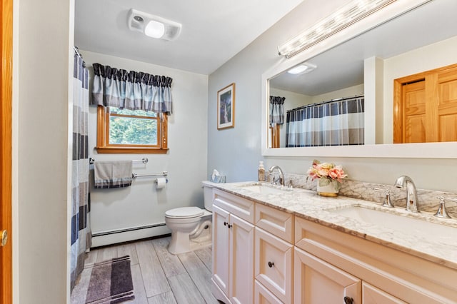 bathroom with vanity, toilet, baseboard heating, and wood-type flooring