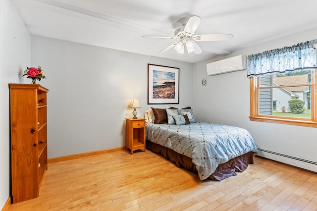 bedroom with ceiling fan, a baseboard radiator, light hardwood / wood-style floors, and a wall mounted air conditioner