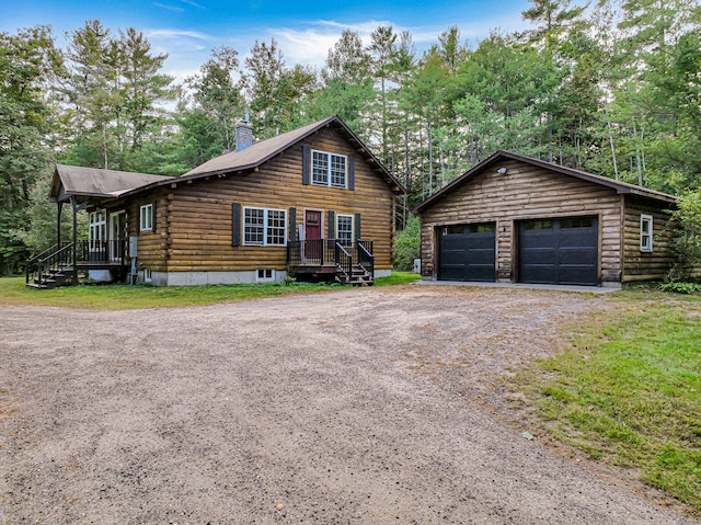 log-style house featuring a garage and an outbuilding