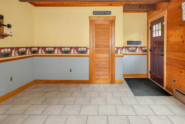 tiled entryway with baseboard heating, wood walls, and wooden ceiling