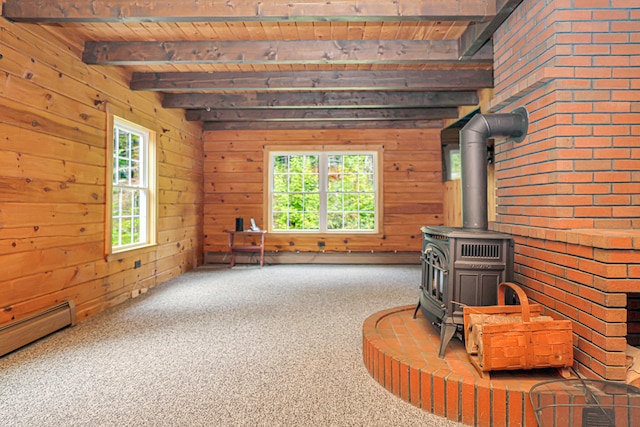 carpeted living room with wood ceiling, wood walls, beamed ceiling, a wood stove, and a baseboard radiator