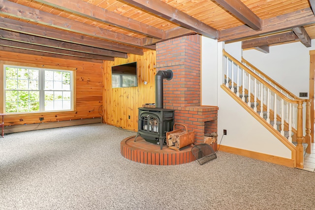 carpeted living room with wooden walls, wood ceiling, a wood stove, a baseboard heating unit, and beamed ceiling