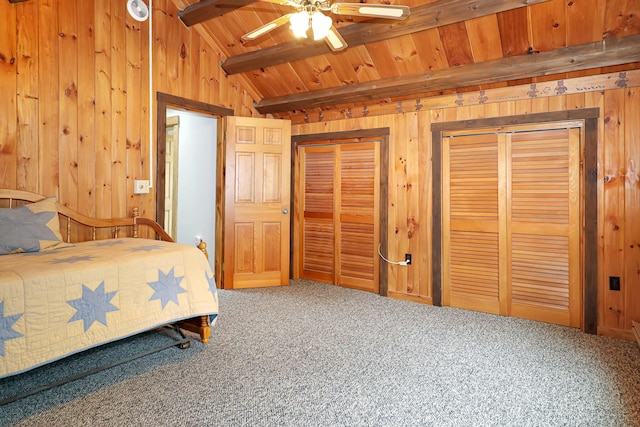 bedroom featuring two closets, wood ceiling, wooden walls, and carpet