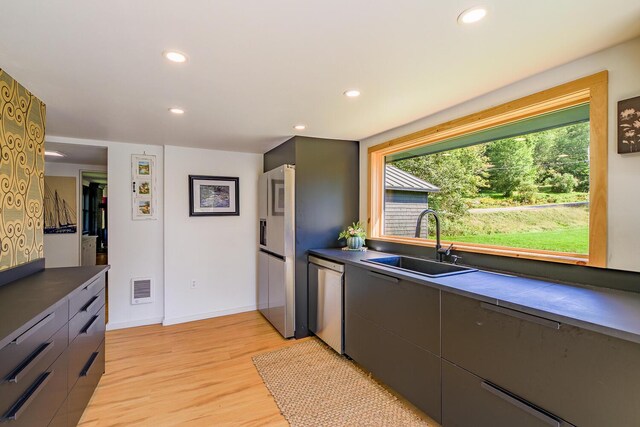 kitchen with sink, light hardwood / wood-style flooring, and stainless steel appliances