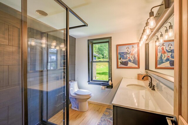 bathroom with vanity, toilet, an enclosed shower, and hardwood / wood-style floors