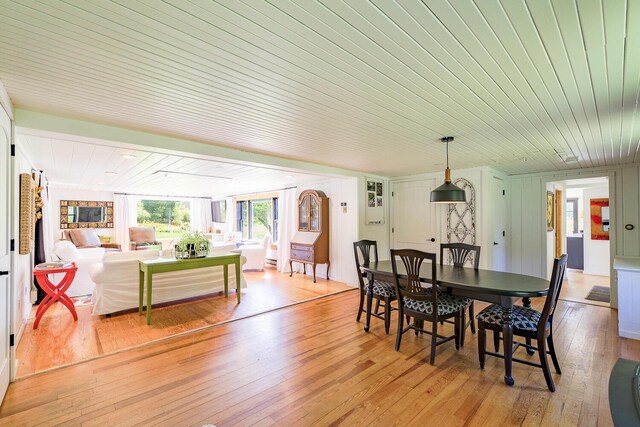 dining area with light hardwood / wood-style flooring and wooden ceiling