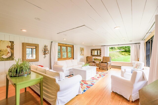 living room featuring a baseboard heating unit and wood-type flooring