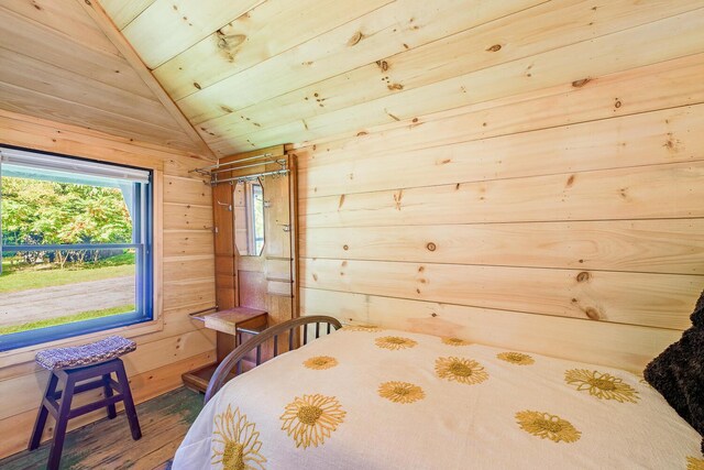 bedroom featuring lofted ceiling, wooden walls, wood-type flooring, and wood ceiling