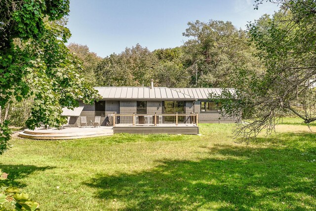 rear view of property with a yard and a deck