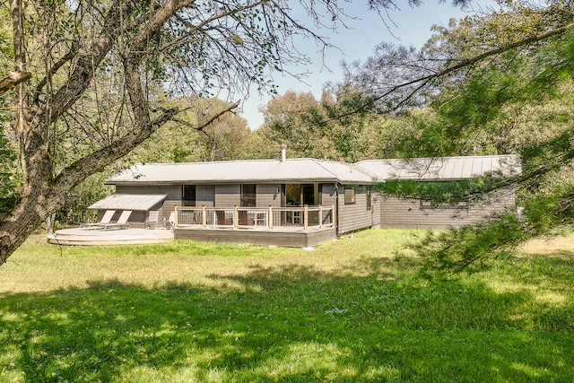 rear view of house with a wooden deck and a lawn