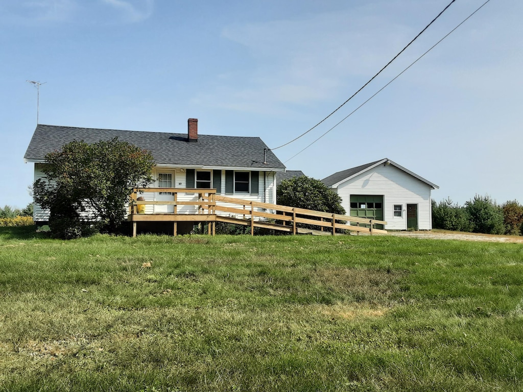 back of property featuring a wooden deck and a lawn