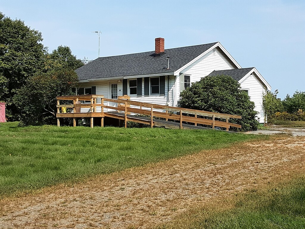 rear view of property with a yard and a deck