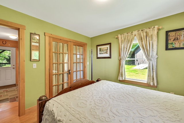 bedroom with multiple windows and hardwood / wood-style flooring