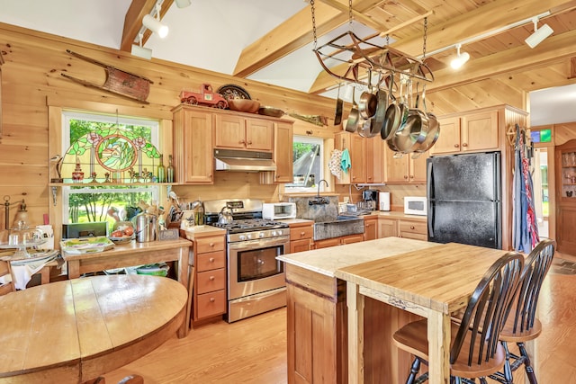 kitchen with black refrigerator, light hardwood / wood-style flooring, light brown cabinetry, and stainless steel range with gas cooktop