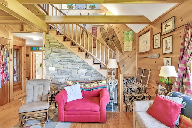 living room with wood walls, stairs, and wood finished floors
