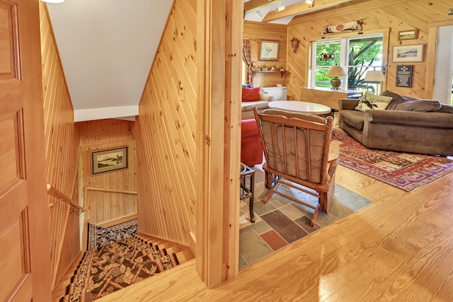 stairs with wooden walls and wood finished floors