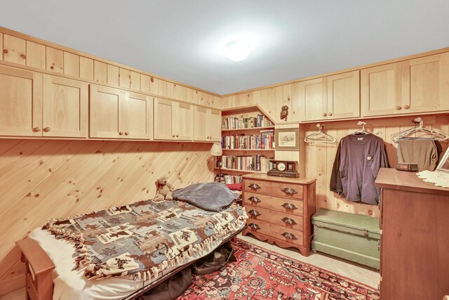 bedroom featuring wooden walls