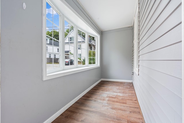 unfurnished room with ornamental molding and wood-type flooring