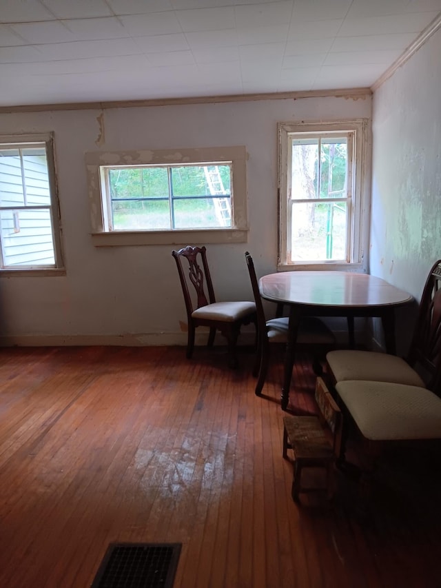 dining space featuring visible vents, crown molding, and hardwood / wood-style flooring