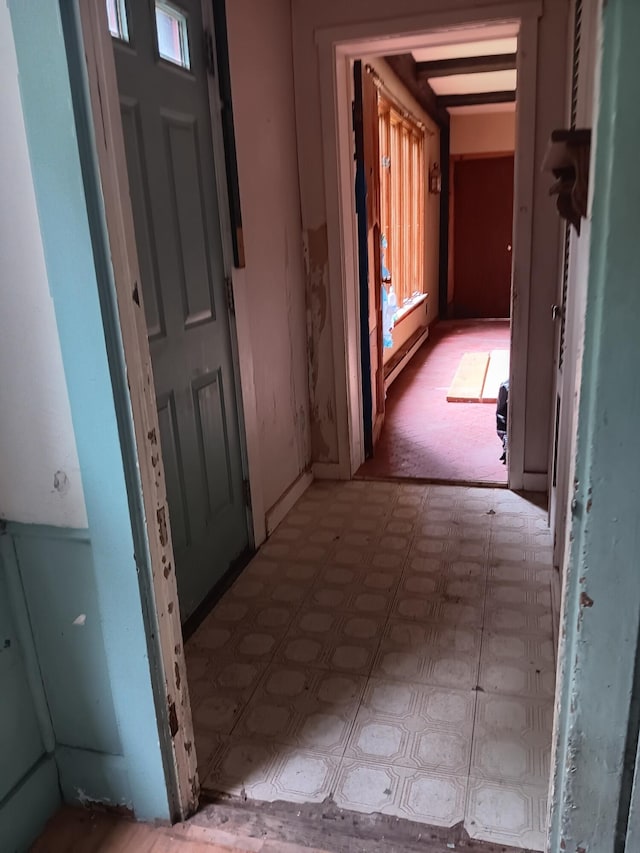 hall with a baseboard radiator and light floors