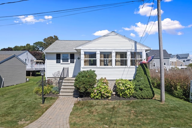 bungalow-style house featuring a deck and a front yard