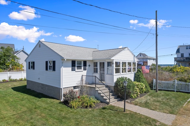 view of front of home featuring a sunroom and a front lawn