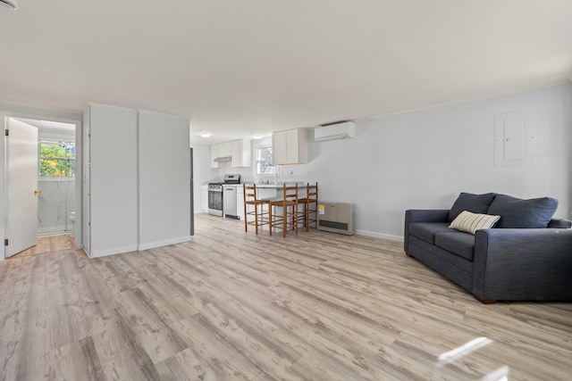 unfurnished living room with light hardwood / wood-style floors and a wall mounted air conditioner