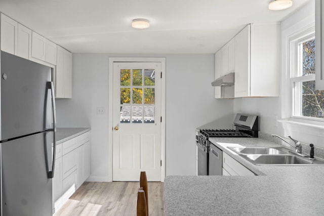 kitchen with light wood-type flooring, white cabinetry, sink, and stainless steel appliances