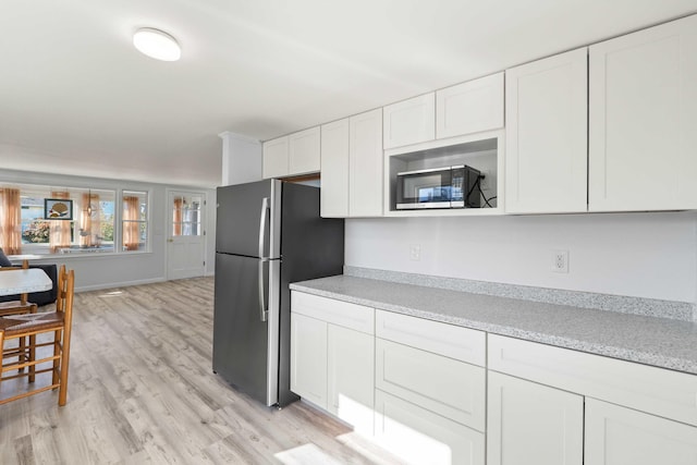 kitchen featuring light hardwood / wood-style floors, white cabinetry, and stainless steel appliances