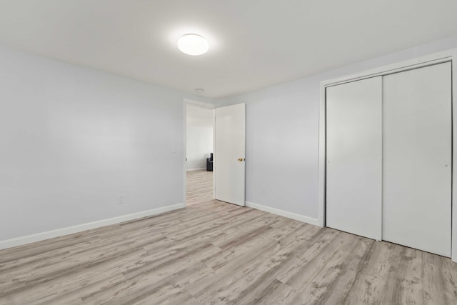 unfurnished bedroom featuring a closet and light hardwood / wood-style floors