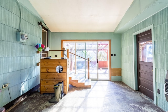 interior space featuring lofted ceiling and concrete floors