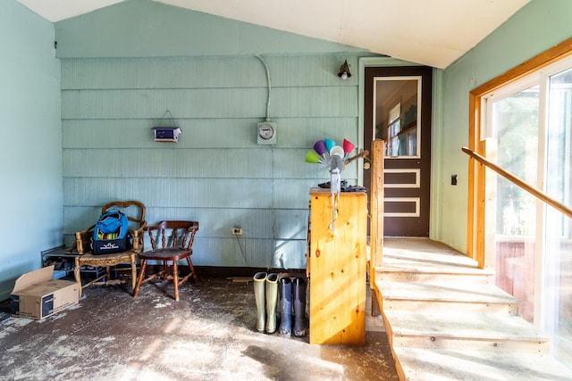 exterior space with vaulted ceiling and concrete flooring