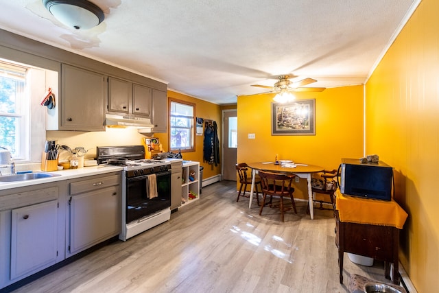 kitchen with white range with gas cooktop, light hardwood / wood-style flooring, baseboard heating, sink, and ceiling fan