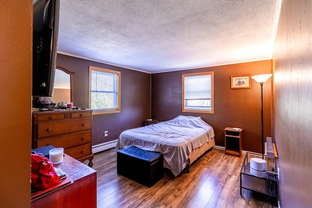 bedroom with multiple windows, hardwood / wood-style floors, baseboard heating, and ornamental molding