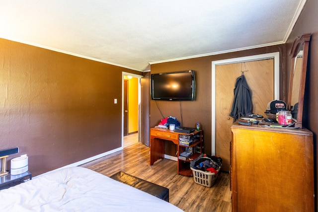 bedroom with crown molding, hardwood / wood-style floors, and a closet