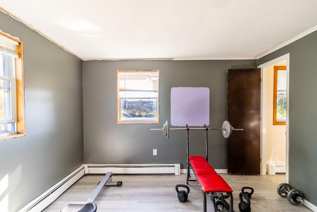 exercise room featuring plenty of natural light, ornamental molding, and a baseboard radiator