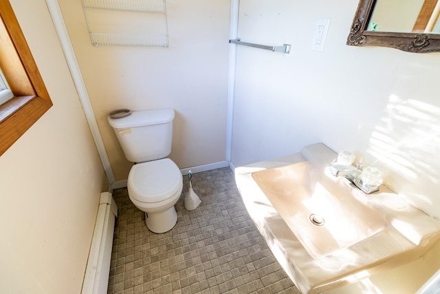 bathroom featuring baseboard heating, toilet, and tile patterned flooring