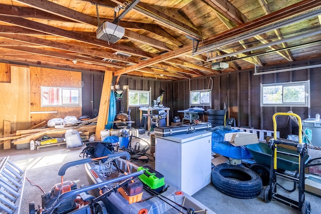 garage featuring a garage door opener and wooden walls