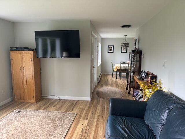87 N Rd, Detroit, ME 04929 - living area featuring light wood-type flooring, baseboards, and a baseboard heating unit