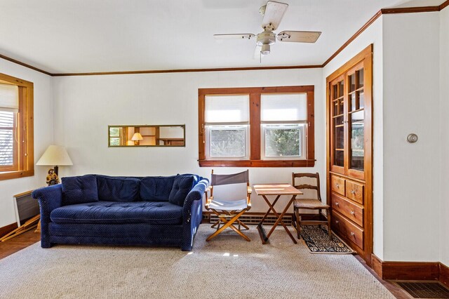 living room with a wealth of natural light, ceiling fan, and crown molding