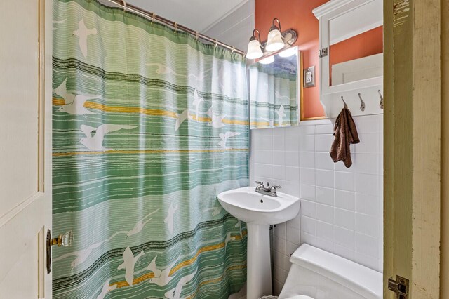 bathroom with walk in shower, tile walls, and toilet