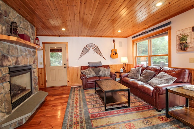 living room featuring a fireplace, a healthy amount of sunlight, hardwood / wood-style floors, and wooden ceiling