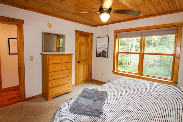 carpeted bedroom with ceiling fan, wood ceiling, and crown molding