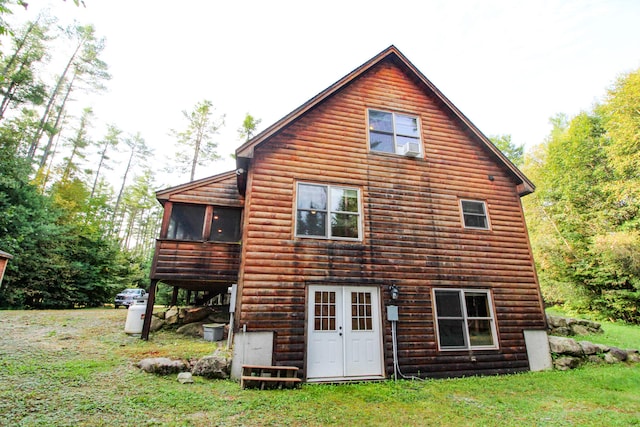 rear view of property with a yard and a sunroom