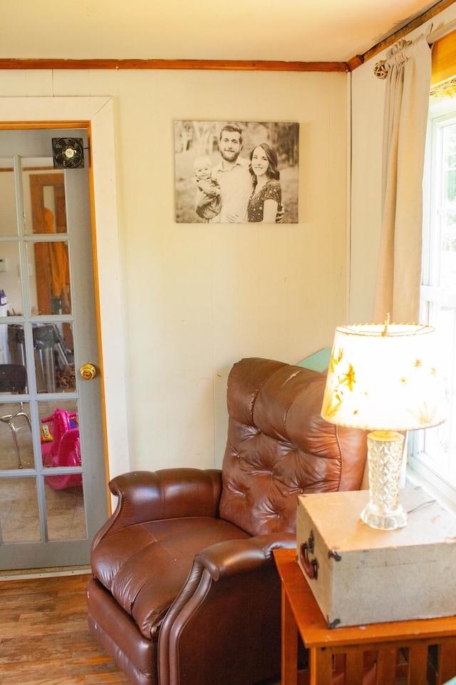 living area with hardwood / wood-style flooring and crown molding