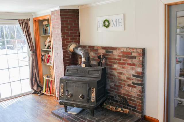 details with hardwood / wood-style flooring, ornamental molding, and a wood stove